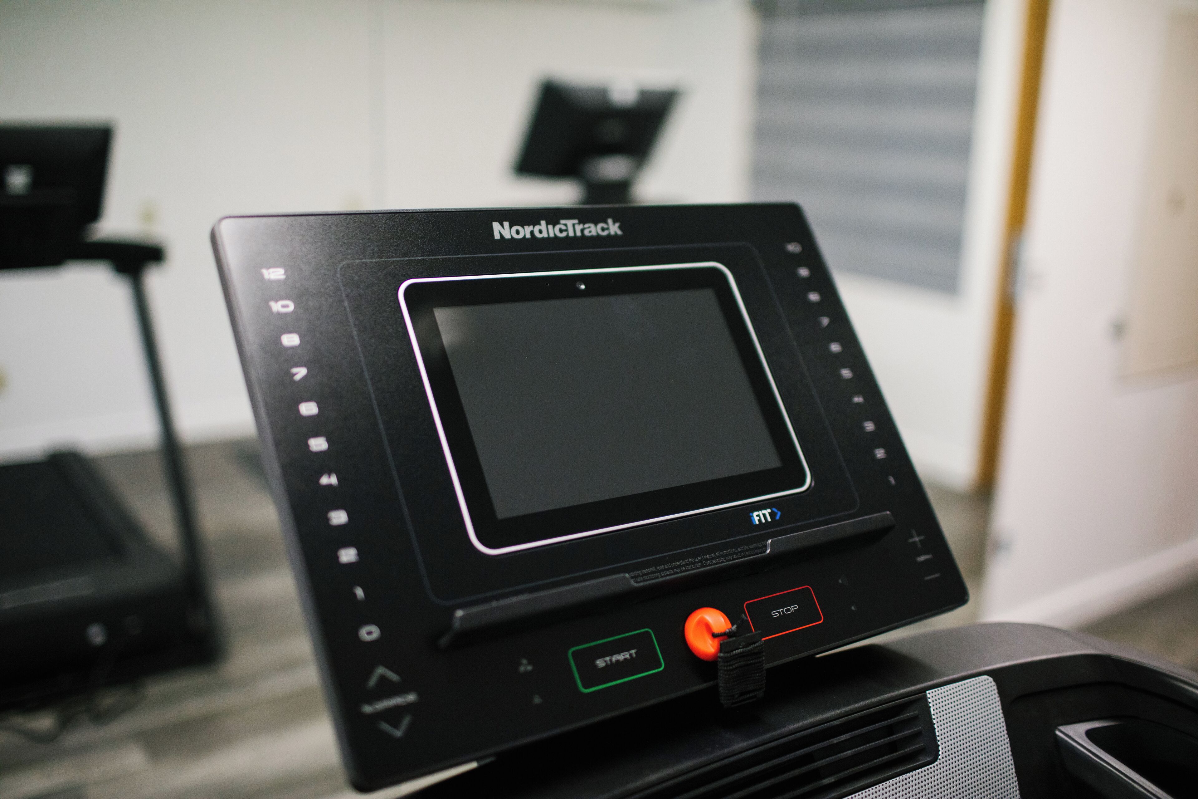 A NordicTrack exercise machine with a digital display, start and stop buttons, and a control panel.