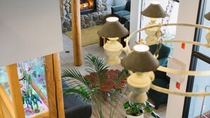 Un interior moderno con chimenea de piedra, lámparas colgantes y un cartel que indica que la propiedad está en venta.