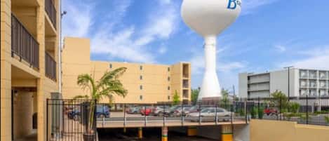 Un hotel con una torre de agua, un aparcamiento y un edificio de varios pisos.