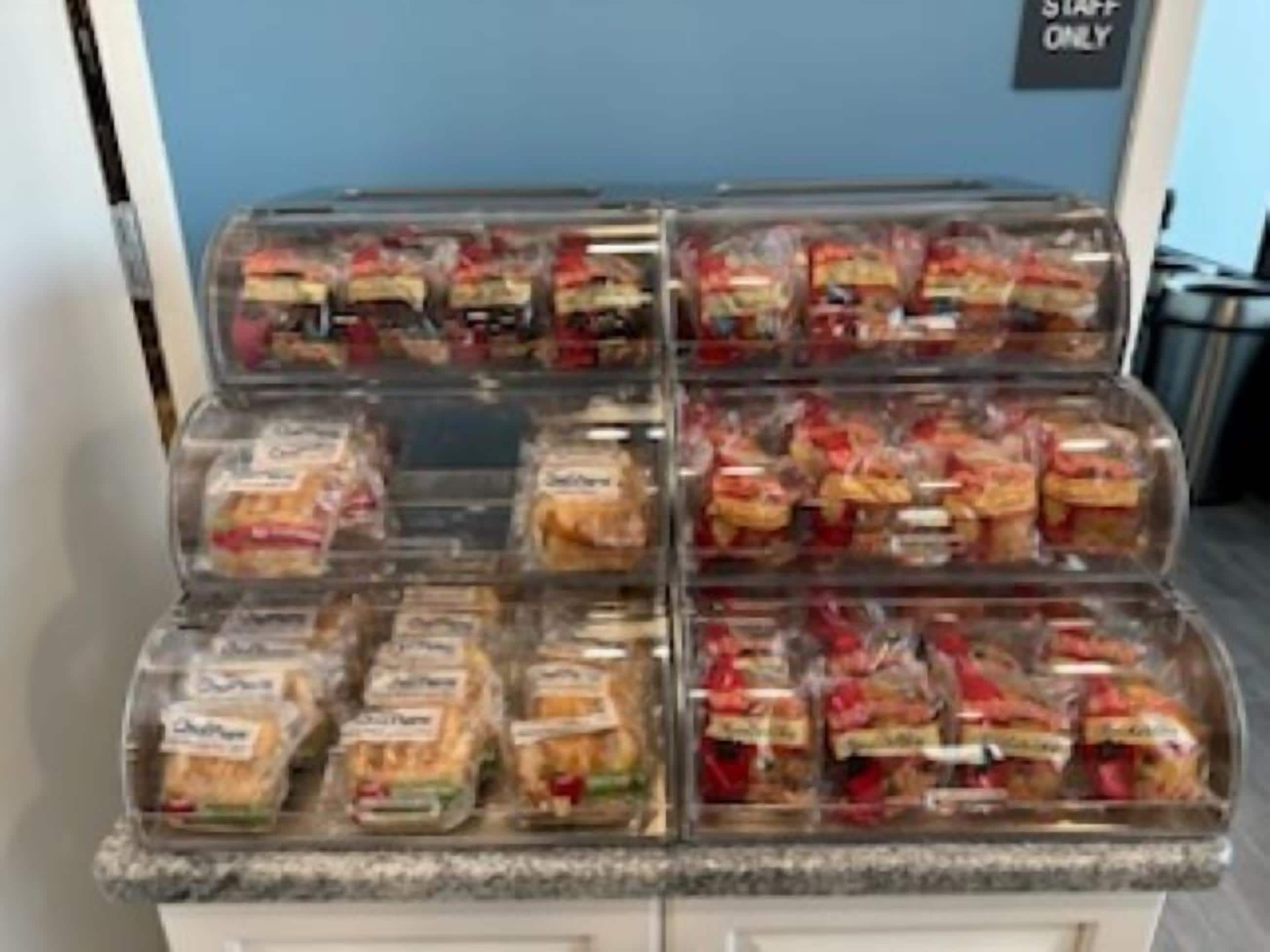 Vitrina refrigerada con diversos productos alimenticios envasados.
