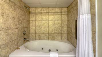 A bathroom with a freestanding bathtub, tiled walls, and a shower curtain.