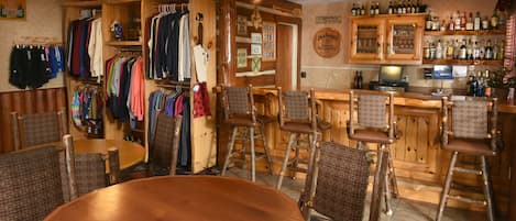 A bar area with wooden furniture, a bar counter, and a seating area with chairs.