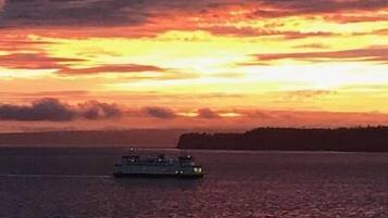 A sunset over a body of water with a pier and a boat.