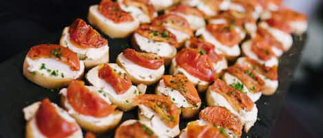 A tray of appetizers with bread, cheese, and tomato slices.
