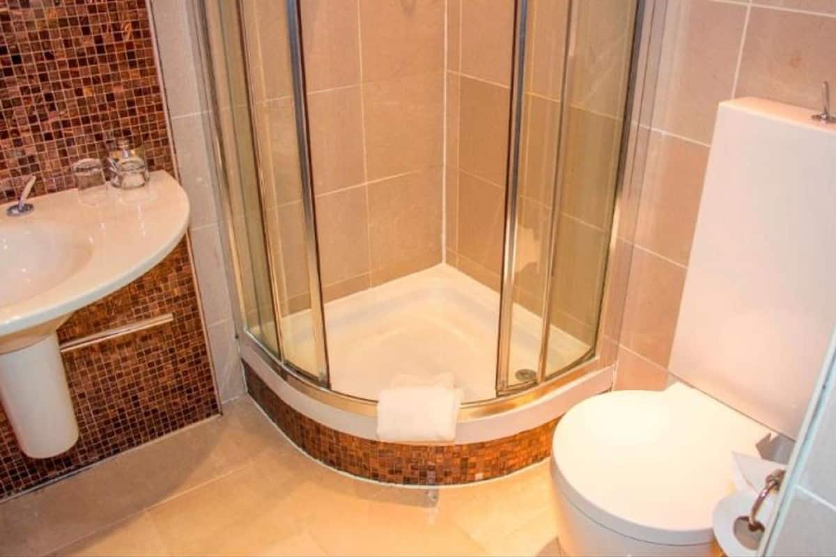 Une salle de bain avec une douche à parois de verre, un lavabo et des toilettes.