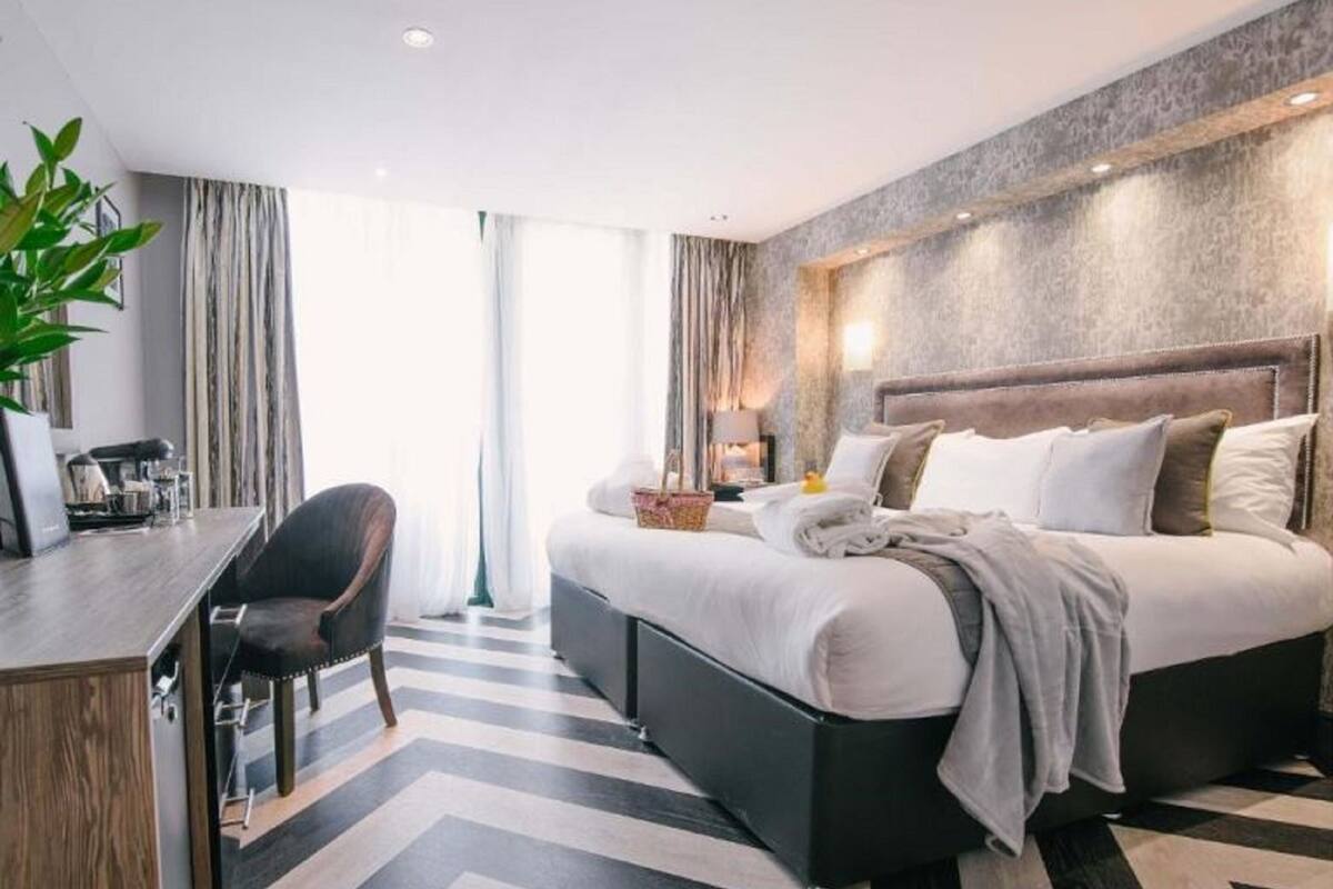 Une chambre d’hôtel moderne avec un grand lit, un bureau et une chaise.