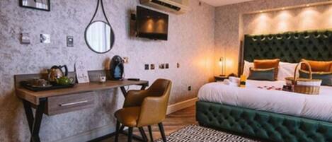 A bedroom with a bed, a desk, a chair, and a patterned rug.