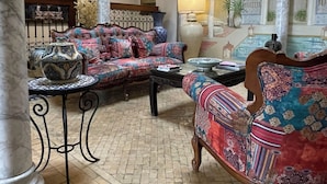 A spacious living area with ornate arches, a patterned sofa, and a tiled floor. - Alcoba del Rey de Sevilla Boutique Hotel (Seville)