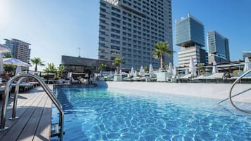 Relax by the pool surrounded by lounge chairs and umbrellas.