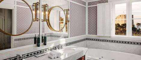Un baño moderno con dos lavamanos, un espejo grande y una bañera.