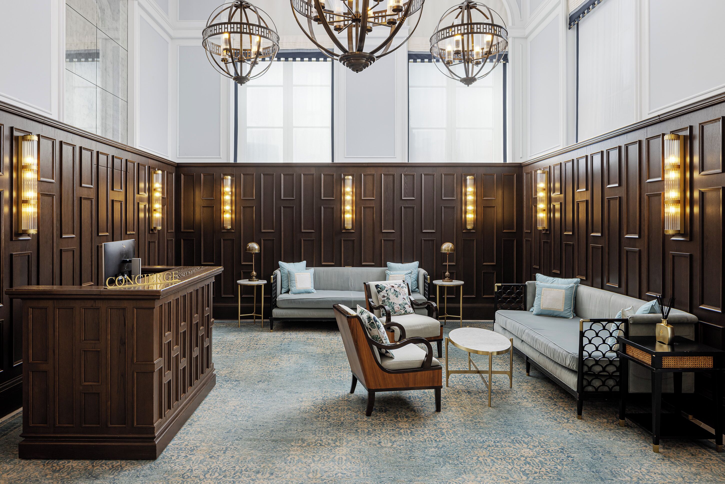 A spacious lobby with a reception desk, seating area, and decorative lighting.