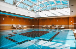 Una piscina techada, sillones reclinables de piscina