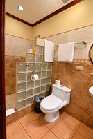 Un baño con inodoro, cabina de ducha y lavabo.