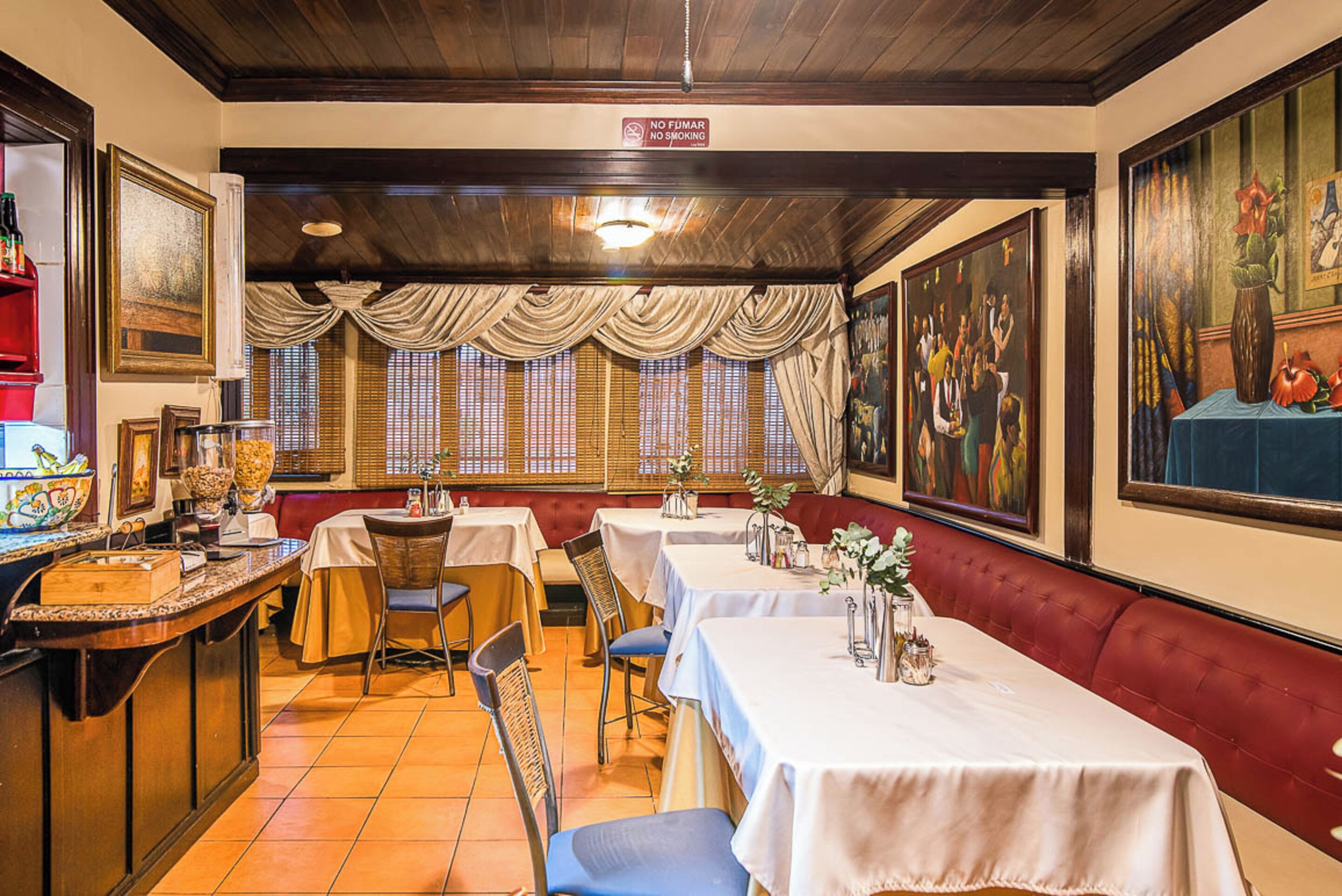 Un restaurant doté de nombreuses tables, de chaises et d’un bar.