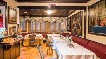 Un restaurant doté de nombreuses tables, de chaises et d’un bar.