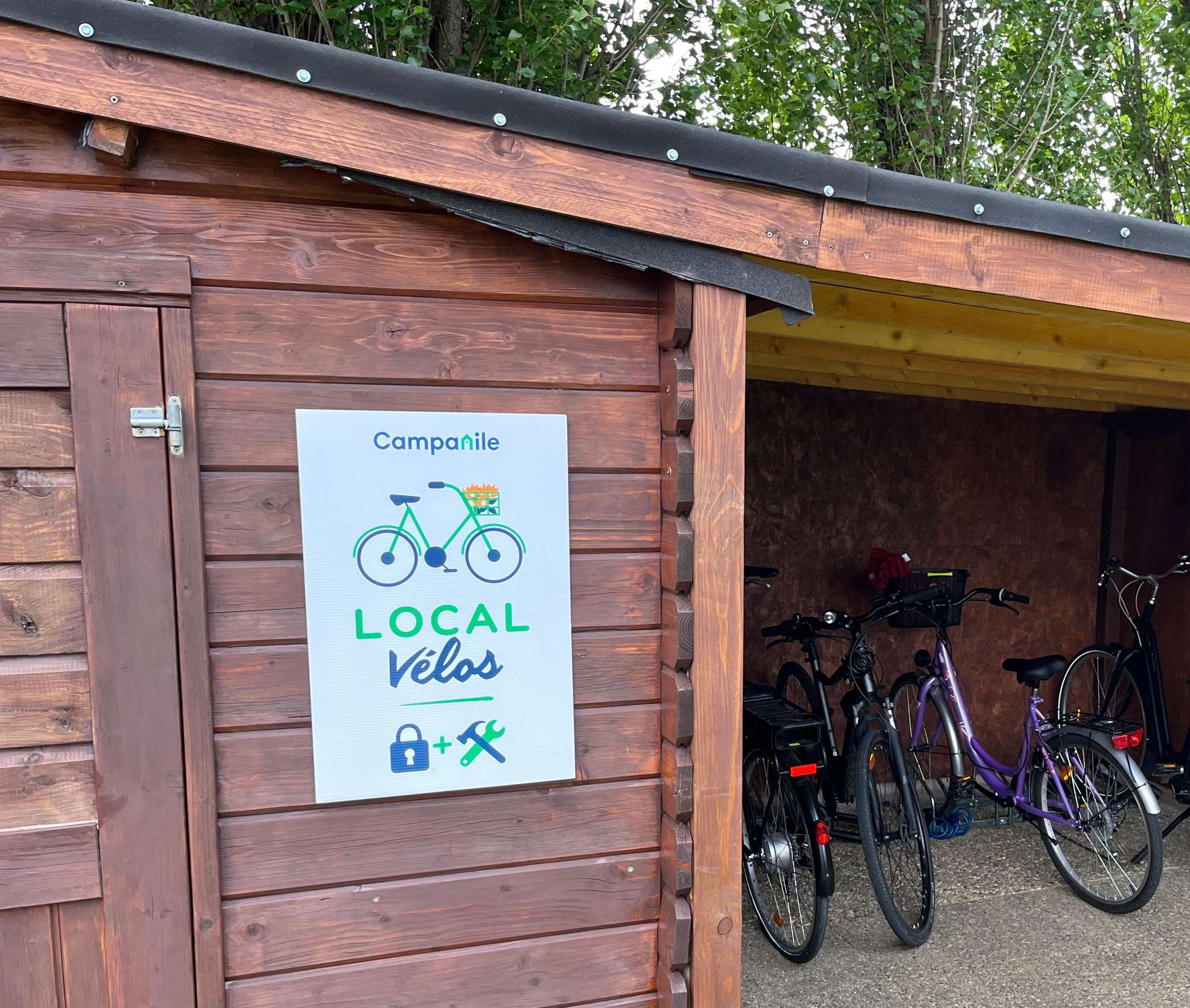 Un bâtiment en bois avec une enseigne qui fait la publicité des services de réparation et d’entretien de vélos proposés dans les environs.