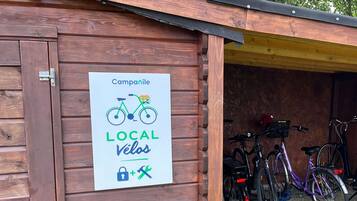 Un bâtiment en bois avec une enseigne qui fait la publicité des services de réparation et d’entretien de vélos proposés dans les environs.