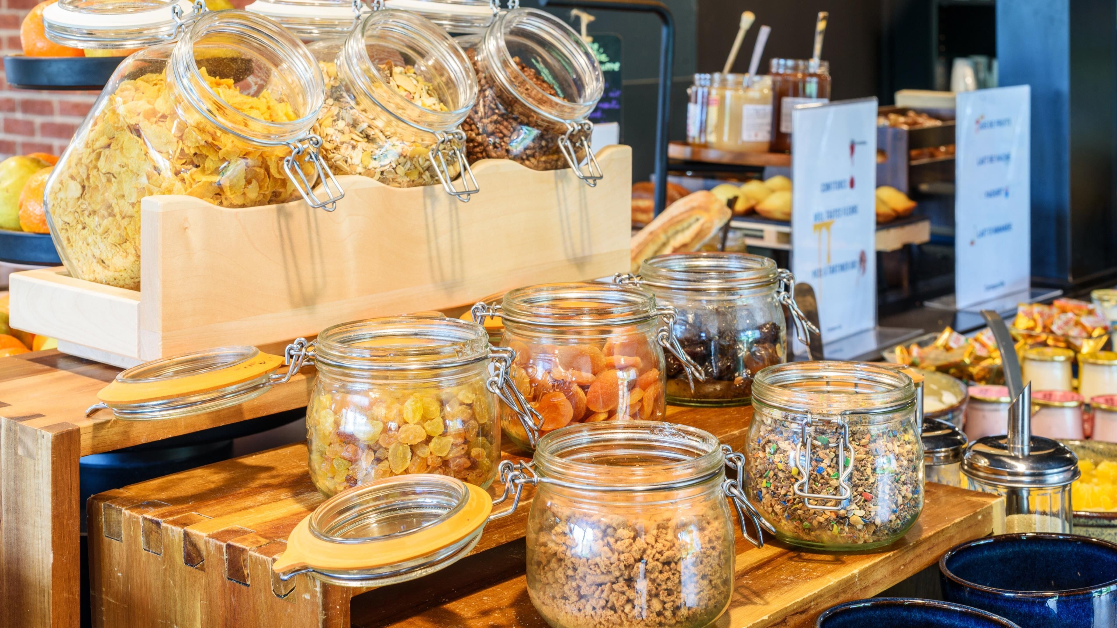 A buffet with various food items in glass jars.
