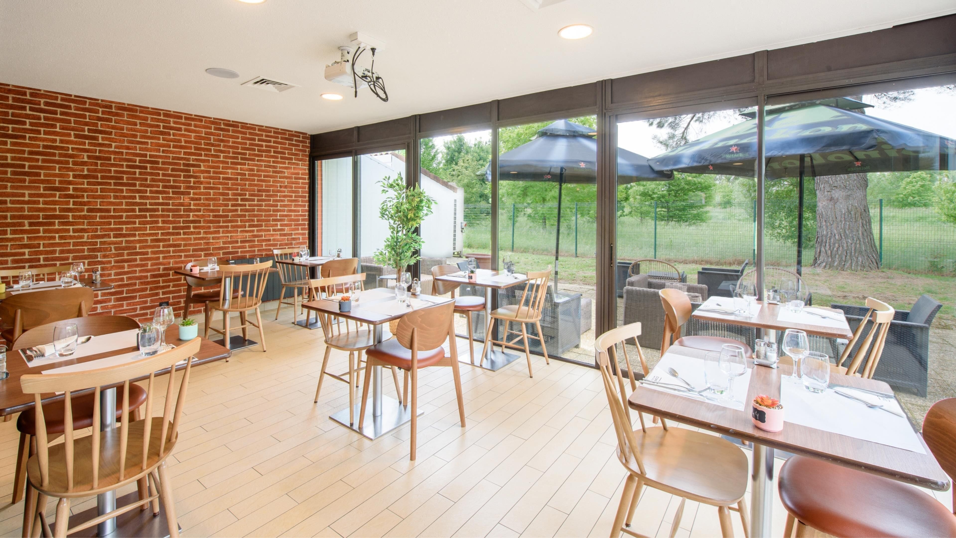 A restaurant with brick walls, wooden tables, and chairs.
