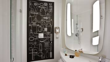 Une salle de bain dotée d’un grand miroir, d’une douche et d’une œuvre d’art murale noire représentant des objets de salle de bain.