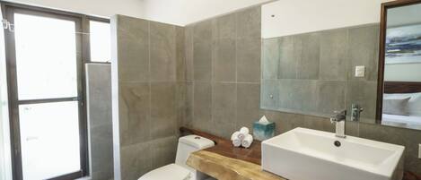 Un baño moderno con una bañera grande, un inodoro y un lavabo.