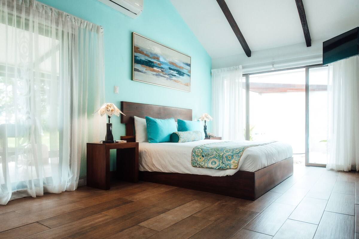 Une chambre à coucher avec un grand lit, une tête de lit en bois et une table de chevet avec une lampe.