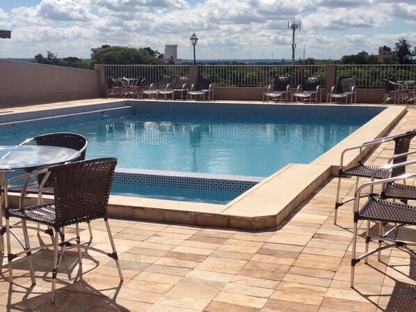 Una piscina al aire libre, tumbonas