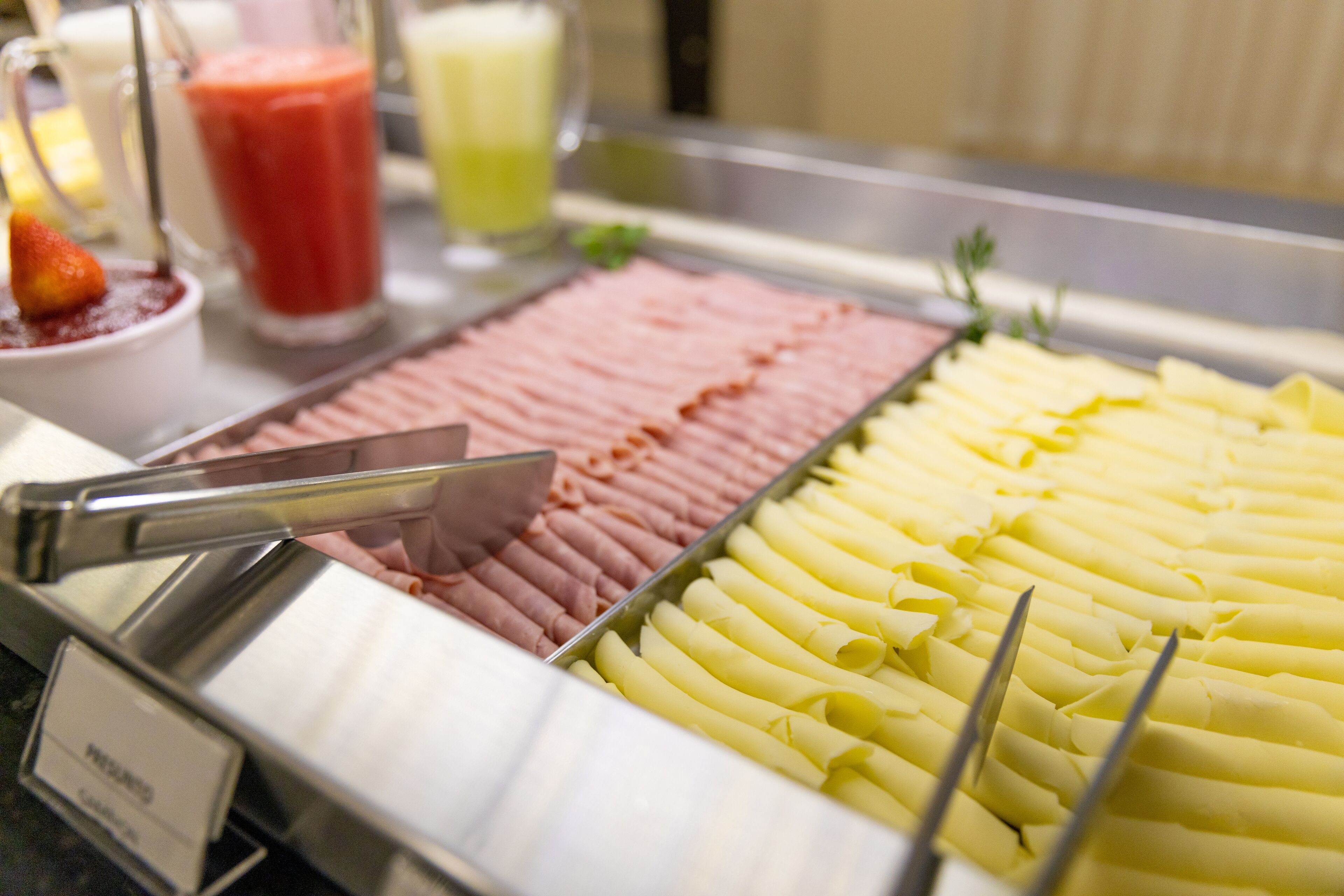 Un buffet proposant une variété de plats, notamment des viandes et des fromages coupés en tranches.