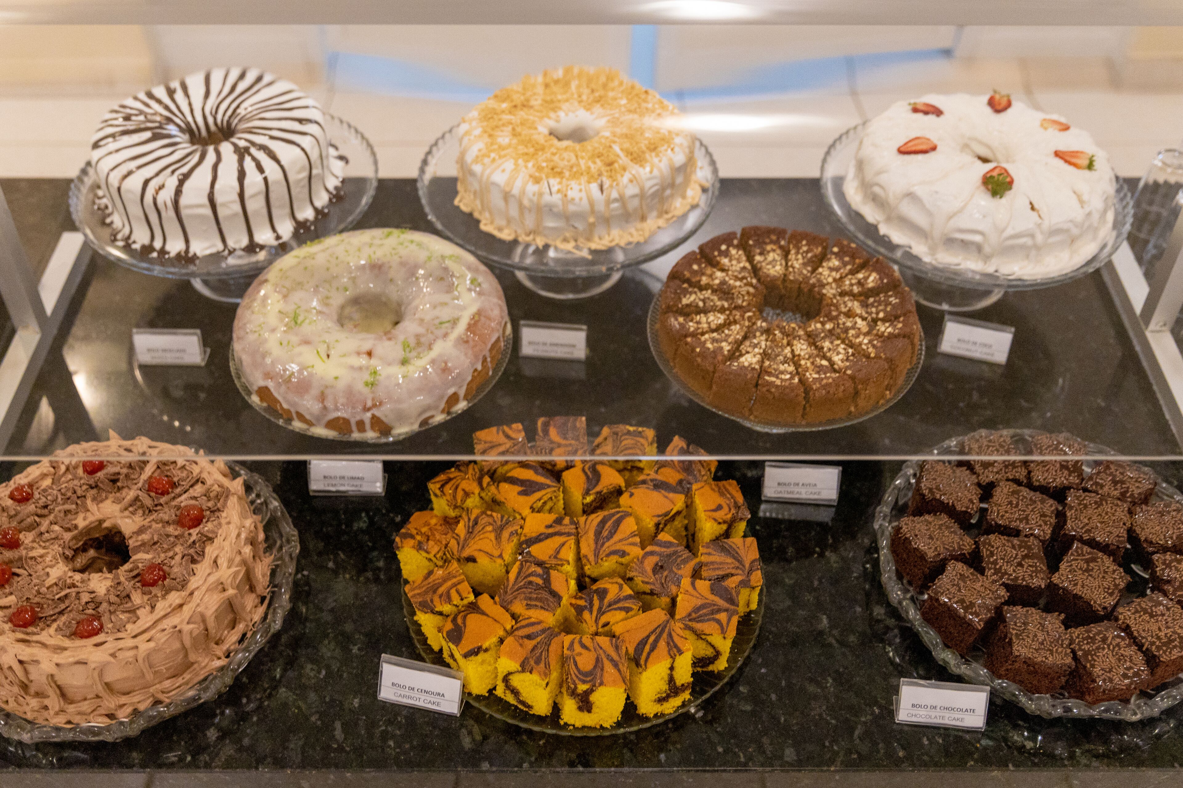 A display case with various cakes and desserts.
