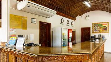 Ein Empfangsbereich mit einer Marmor-Theke, Holztüren, einer Uhr und einer Wand-Klimaanlage.