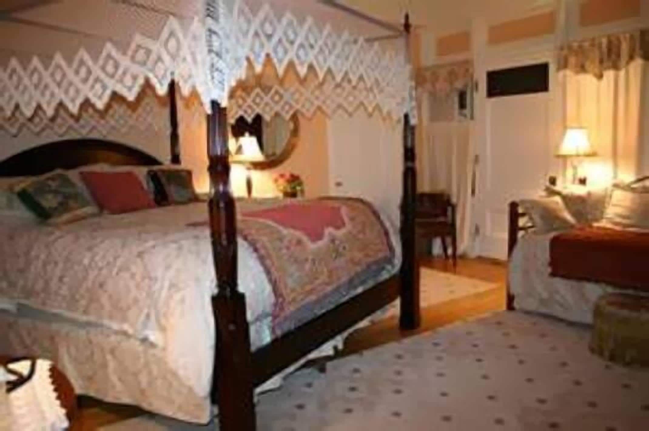 Una cama con dosel y doselaje, con un edredón estampado.