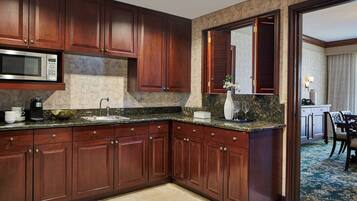A kitchen with wooden cabinets, a microwave, and a sink.