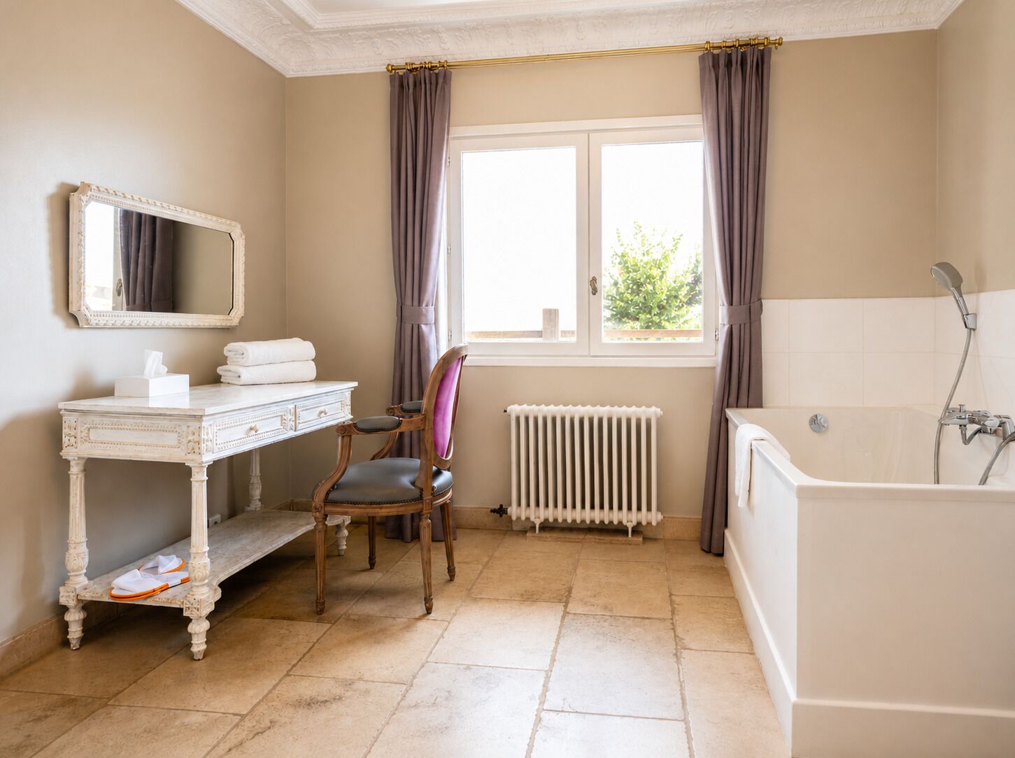 A bathroom with a white vanity, a chair, a radiator, and a bathtub.
