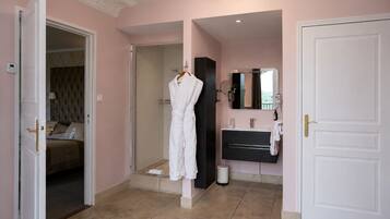 A hotel room with a bed, a bathroom with a mirror, and a door.