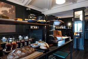 Een ontbijtbuffet met brood, gebak en toevoegingen.