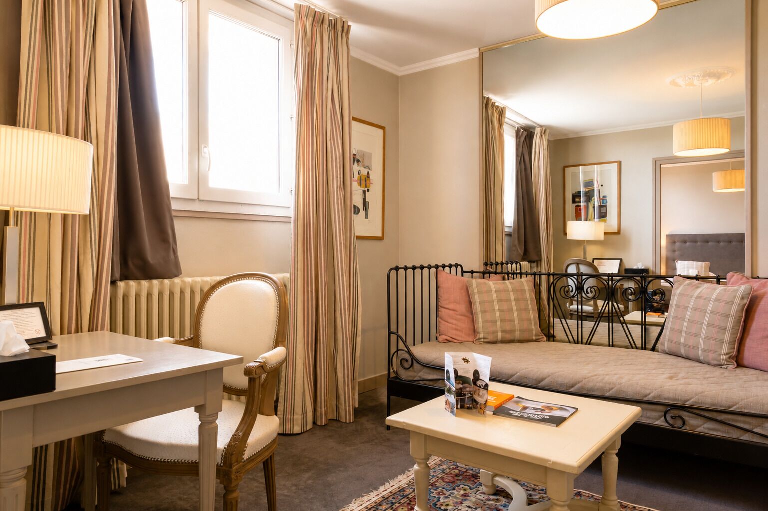Een hotelkamer met een bed, een bureau, een stoel, een tafel en een spiegel.