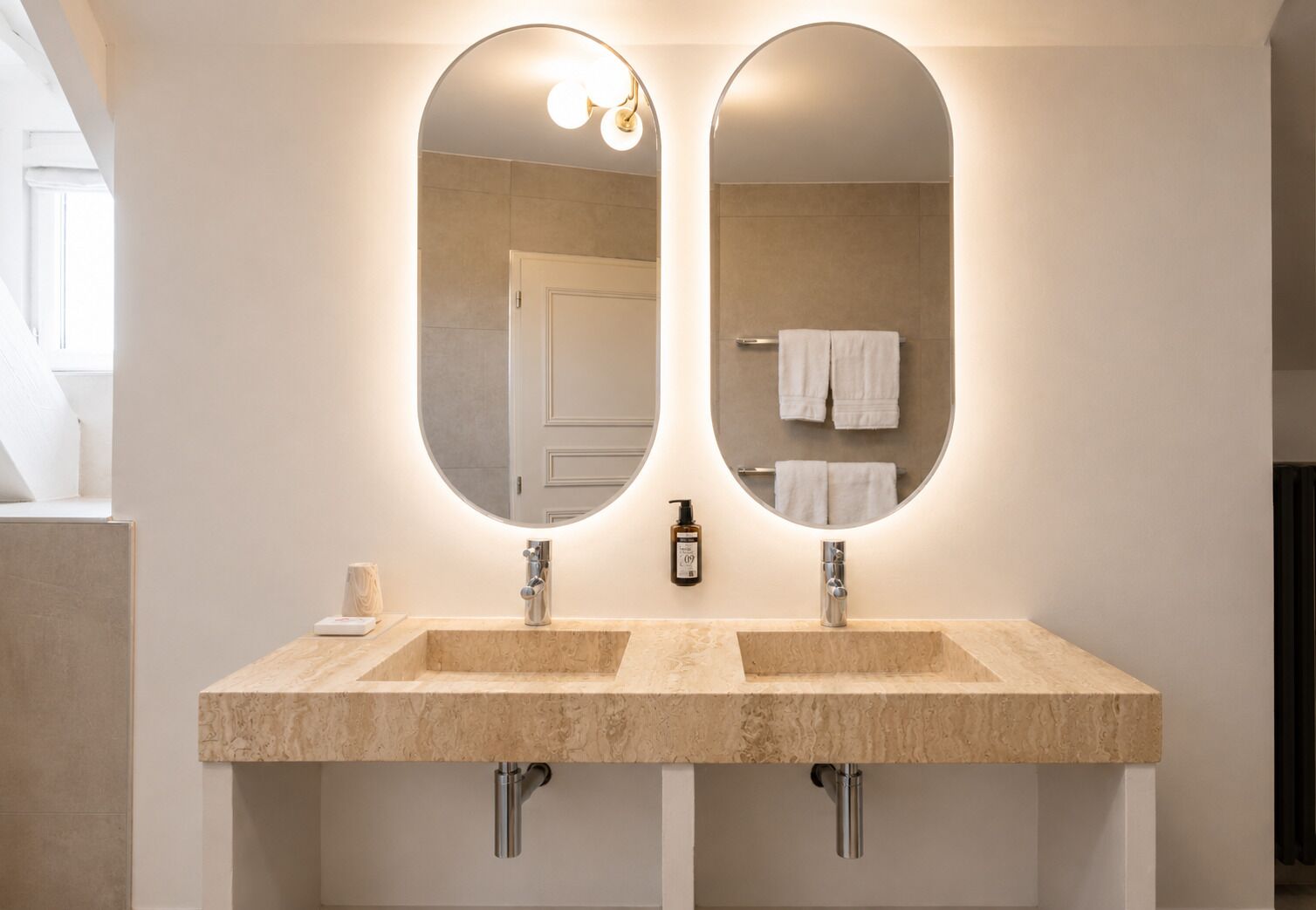 A bathroom with two sinks, a mirror, and a towel rack.