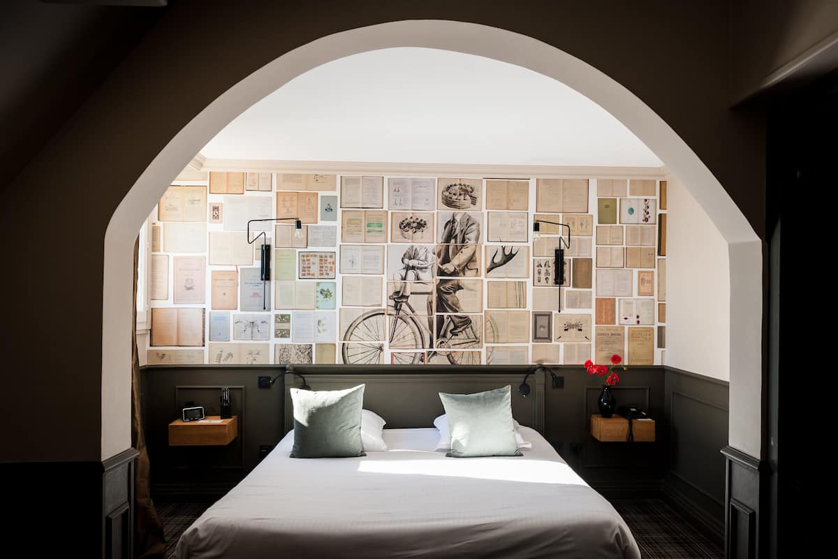 Ein Schlafzimmer mit einem großen Bett, einer Wand voller Zertifikate und einer gewölbten Decke.