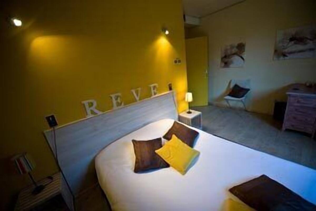 A bedroom with a bed, a nightstand, a chair, and a dresser.