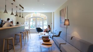 A modern interior with a reception area, seating, and a large window.