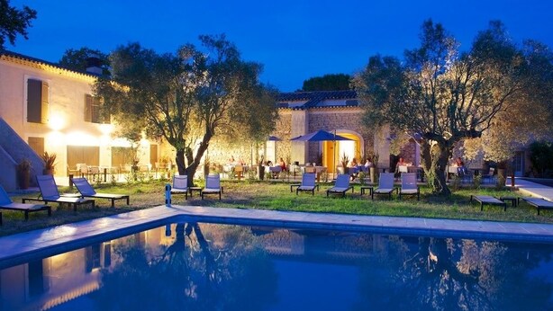 A poolside area with lounge chairs and a building in the background.