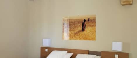 Ein Schlafzimmer mit einem großen Bett, einem Holzkopfende, Nachttischen und einem Bild an der Wand.