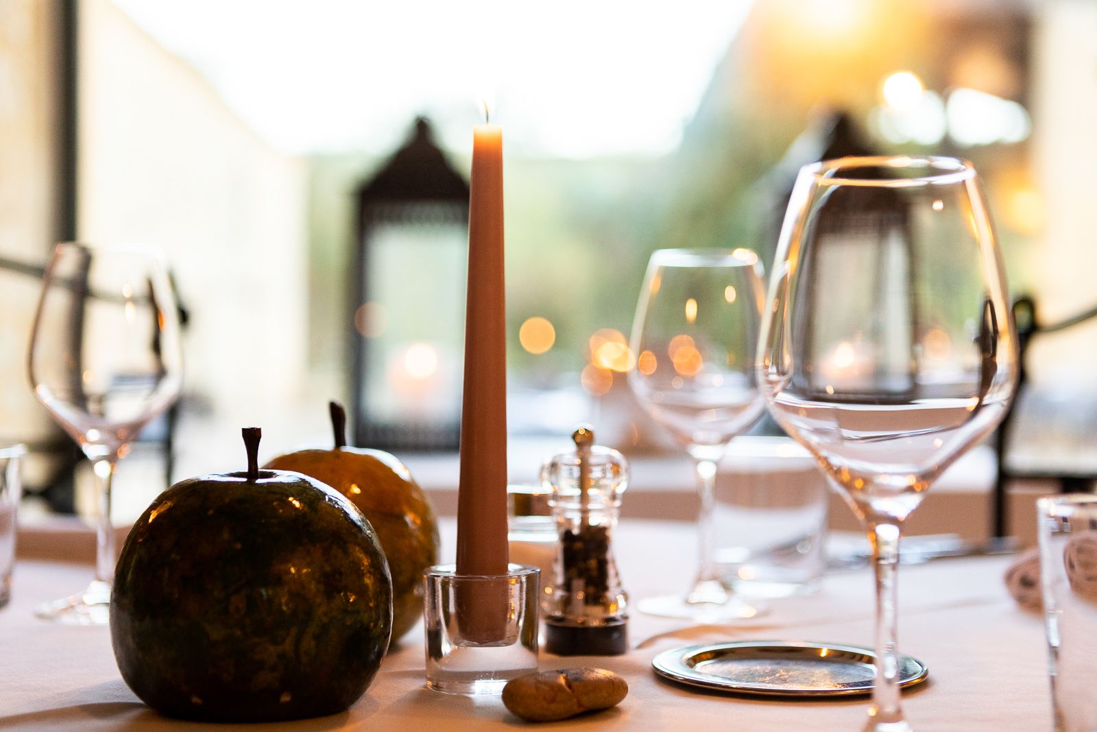 A table set with wine glasses, a candle, and decorative items.