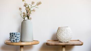 Two small wooden tables with vases on them.