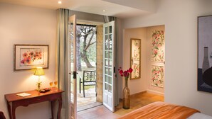 Une chambre d’hôtel avec un lit, un bureau doté d’une lampe, une chaise et une vue sur l’extérieur.