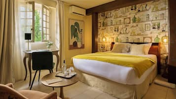 Een hotelkamer met een bed, een bureau, een stoel en een klein tafeltje met een dienblad.