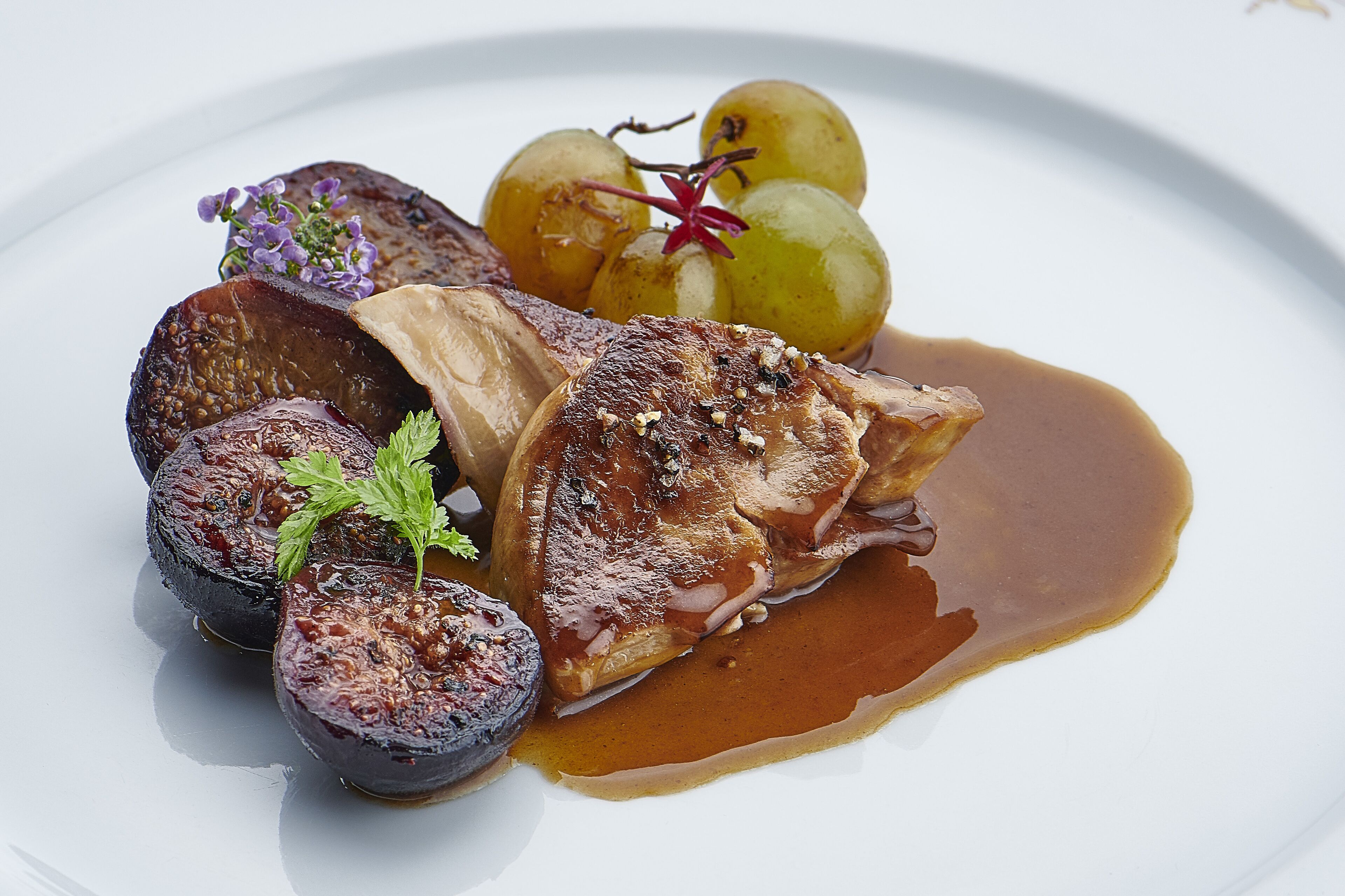 Une assiette contenant un morceau de viande, des légumes et une sauce.