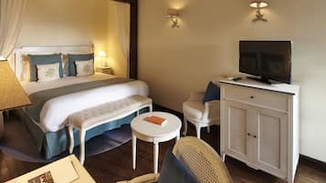Une chambre d’hôtel avec un lit, un téléviseur posé sur un meuble, une petite table ronde, une chaise et un bureau.
