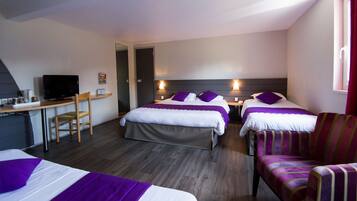 A hotel room with two beds, a desk, a chair, and a television.