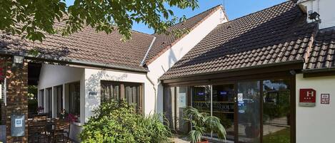 A building with a tiled roof and a glass door entrance.